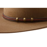 Brown cowboy hat with braided leather band and copper studs on a white background
