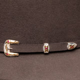 Close-up of a belt with gold and silver buckles on a brown background
