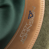 Close-up of a brown leather strap with 'Johnny Johnny' branding on a green and brown background.