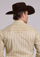 Man wearing a patterned shirt and cowboy hat against a gray background