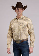 Man wearing a patterned long-sleeve shirt, jeans, and a cowboy hat on a gray background